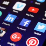 Smartphone screen showing social media app icons including Facebook, Instagram, LinkedIn, YouTube, Twitter, and Pinterest