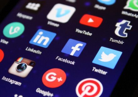 Smartphone screen showing social media app icons including Facebook, Instagram, LinkedIn, YouTube, Twitter, and Pinterest