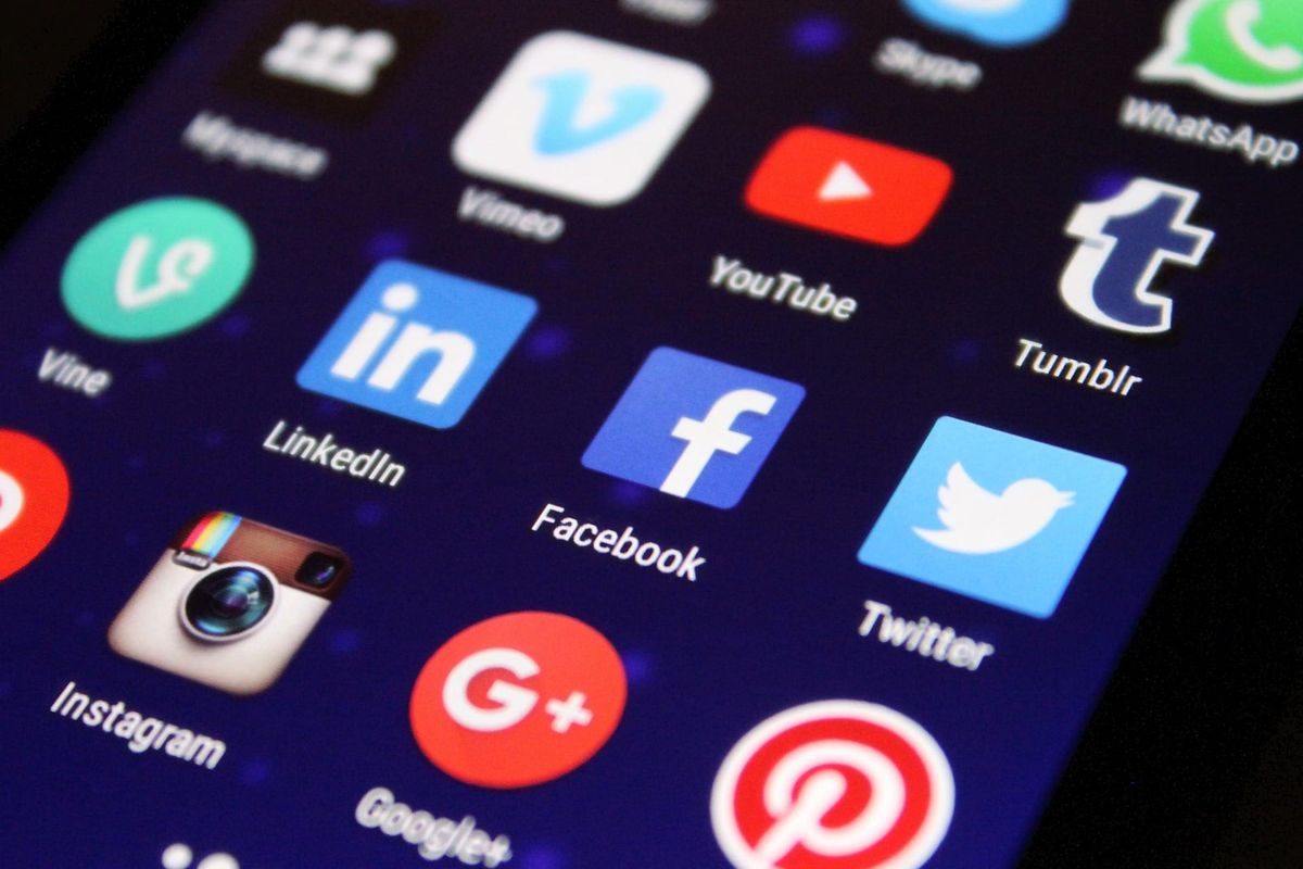 Smartphone screen showing social media app icons including Facebook, Instagram, LinkedIn, YouTube, Twitter, and Pinterest