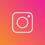 White Instagram camera icon on a pink, red, and orange gradient background
