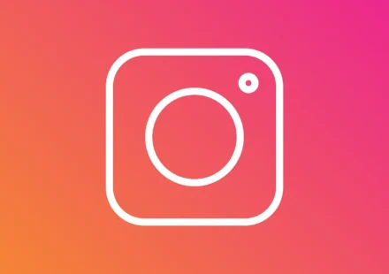 White Instagram camera icon on a pink, red, and orange gradient background