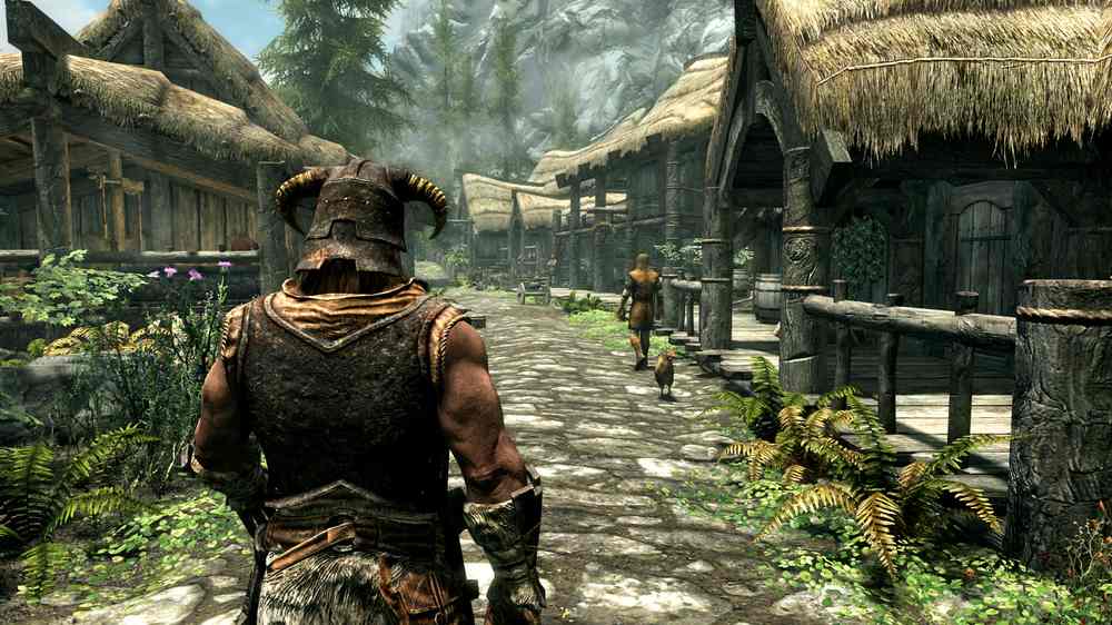 The Dragonborn walking through a village street past thatched-roof buildings